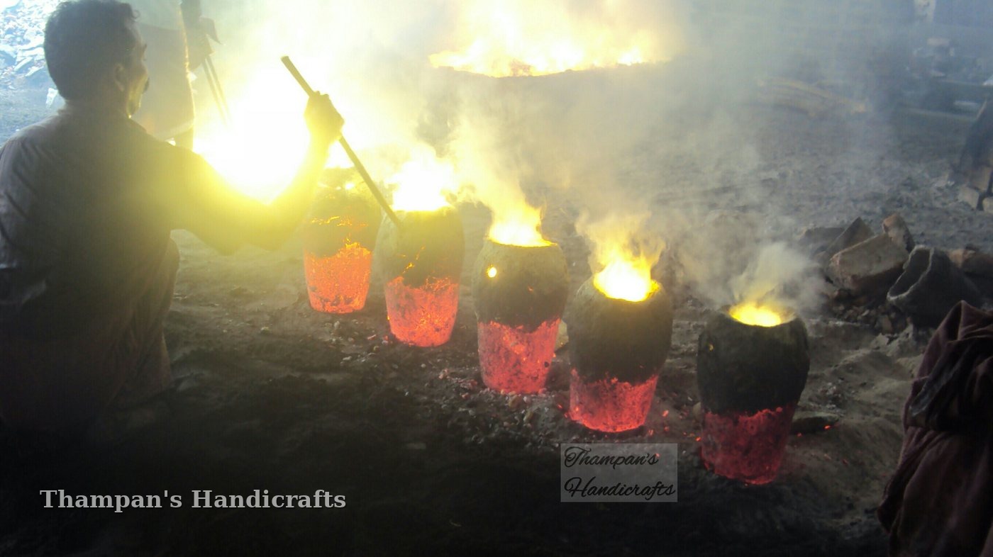 Mud crucibles of melting bronze glowing red-hot at Thampan's Handicrafts foundry in Mannar, Kerala